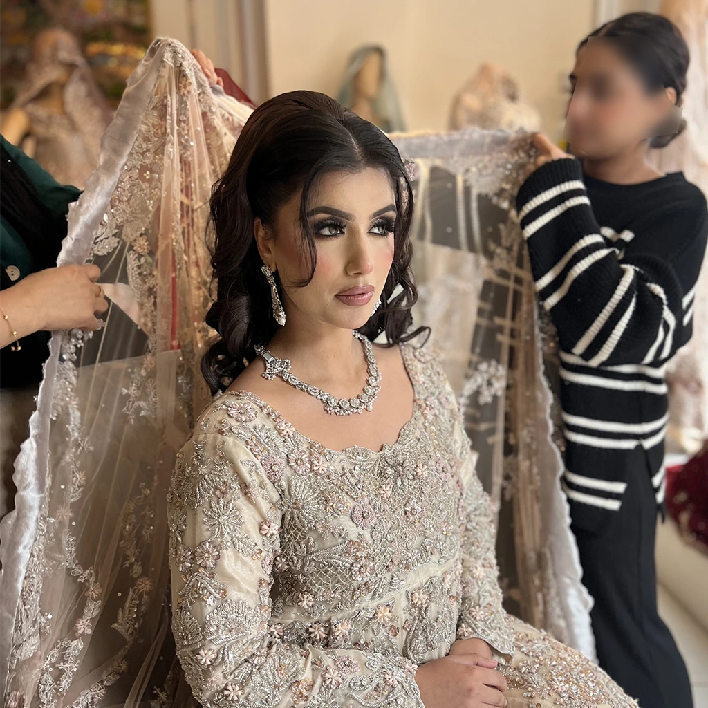 A behind-the-scenes image of a bride trying on her dress in a fitting room.