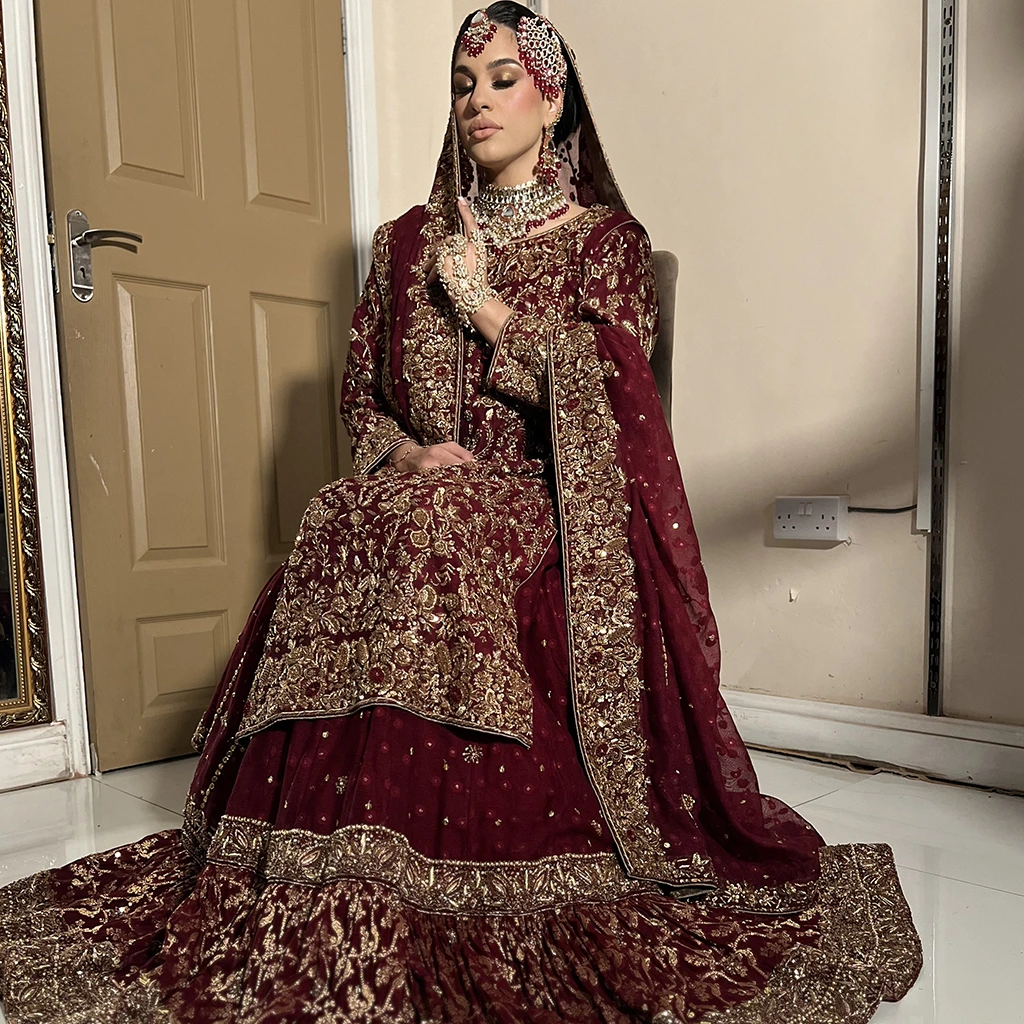 A bride in a deep maroon velvet lehenga