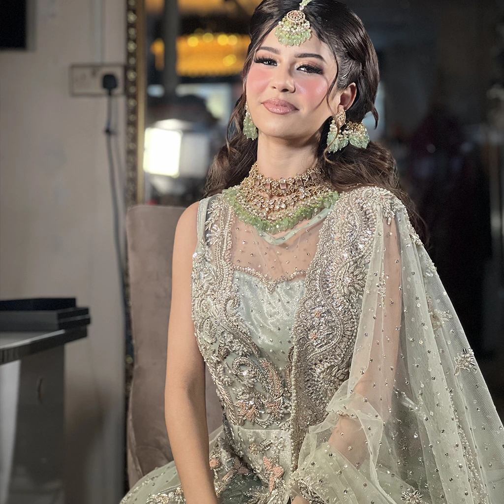 Mehndi bride in a yellow outfit with vibrant mirror work and colorful thread embroidery.