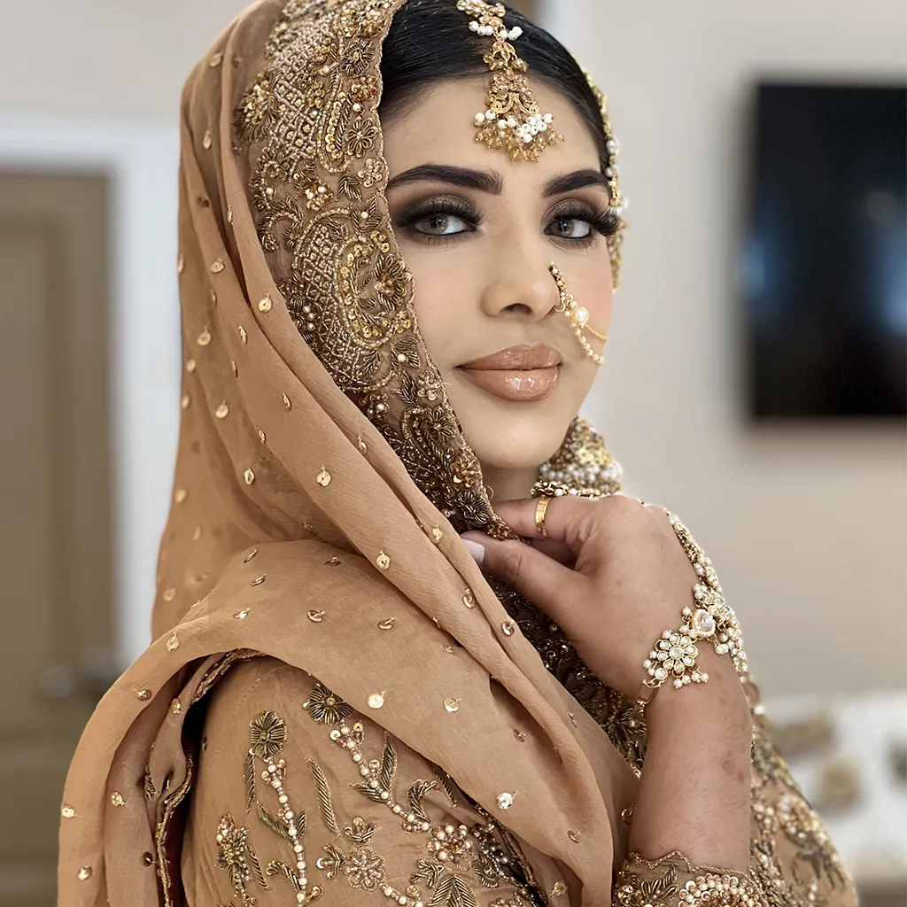 Close-up of intricate embroidery, pearls, and Rococo floral motifs on pastel bridal fabrics.